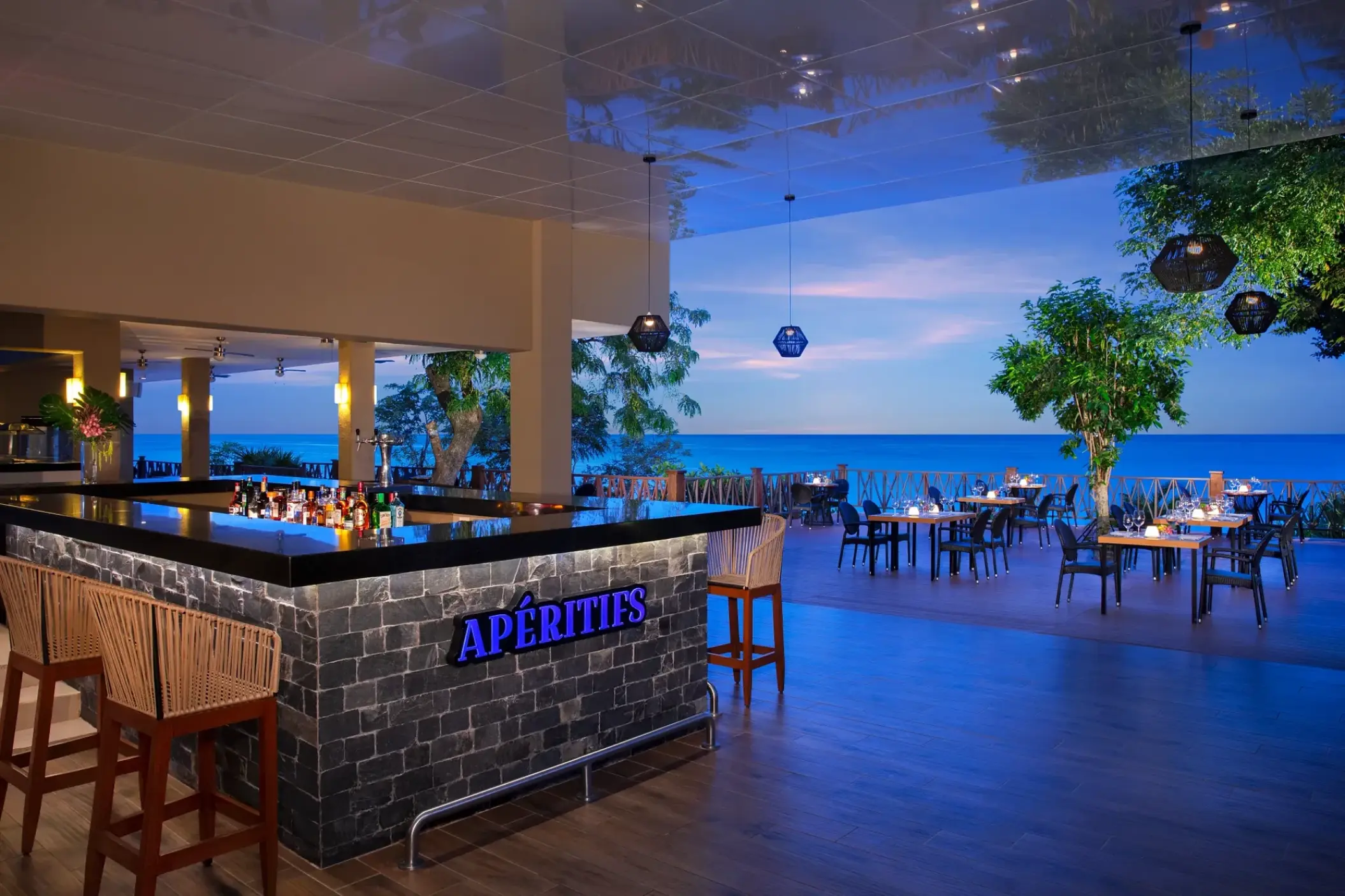 Aperitifs bar and outdoor lounge overlooking the ocean at sunset at Dreams Cozumel Cape, Cozumel