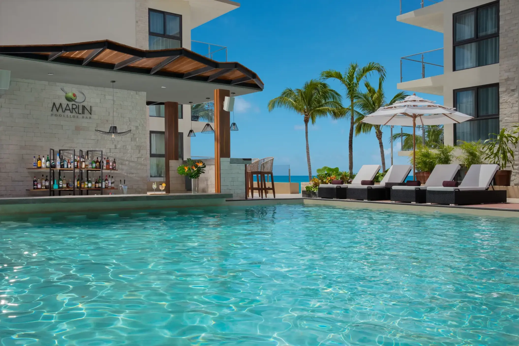 Marlin swim-up bar and poolside lounge chairs at Dreams Cozumel Cape, Cozumel