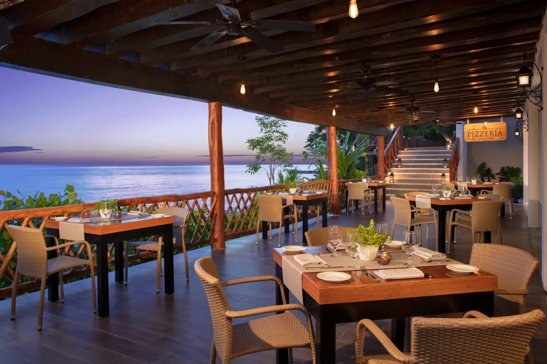 Outdoor pizzeria terrace at Dreams Cozumel Cape overlooking the ocean at sunset, Cozumel