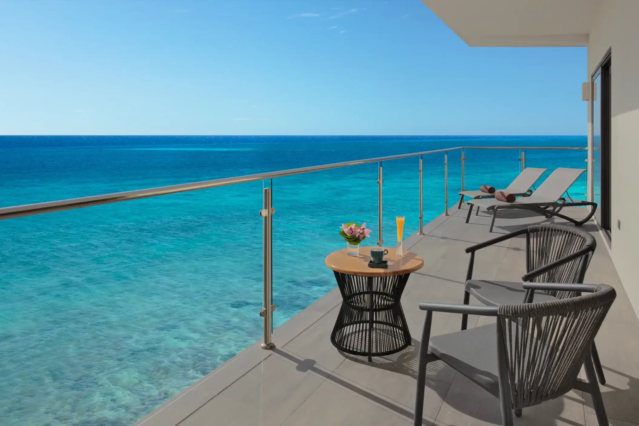 Master suite ocean view balcony with lounge chairs and seating at Dreams Cozumel, Cozumel