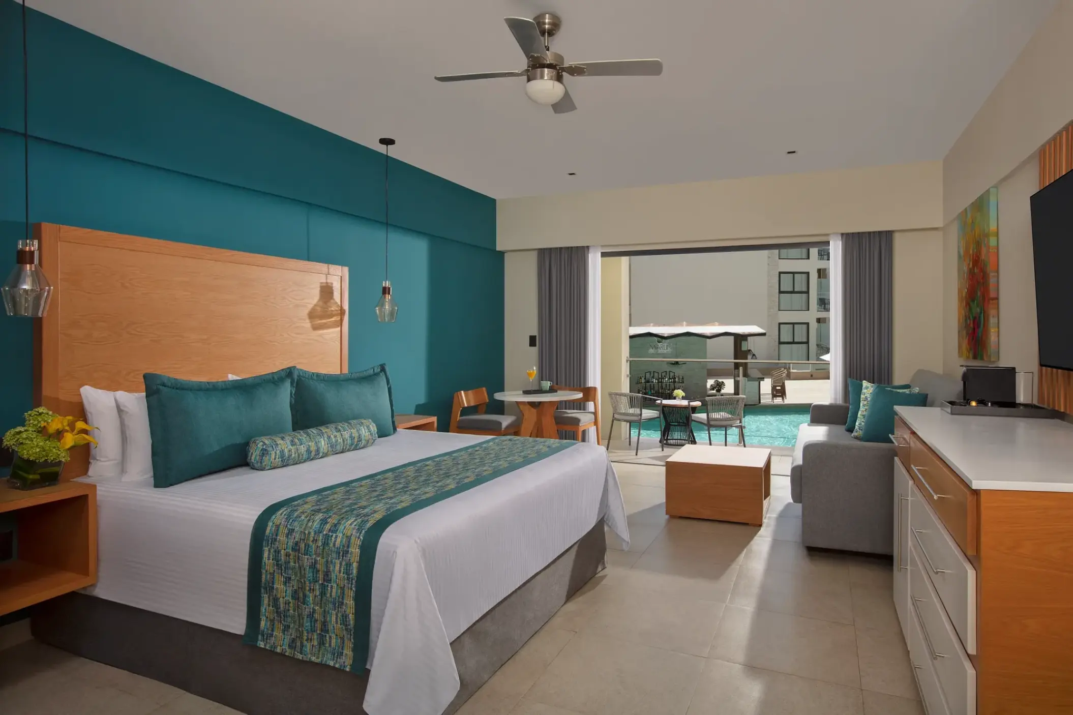Preferred Club Junior Suite pool view with teal accents and a private balcony at Dreams Cozumel, Cozumel