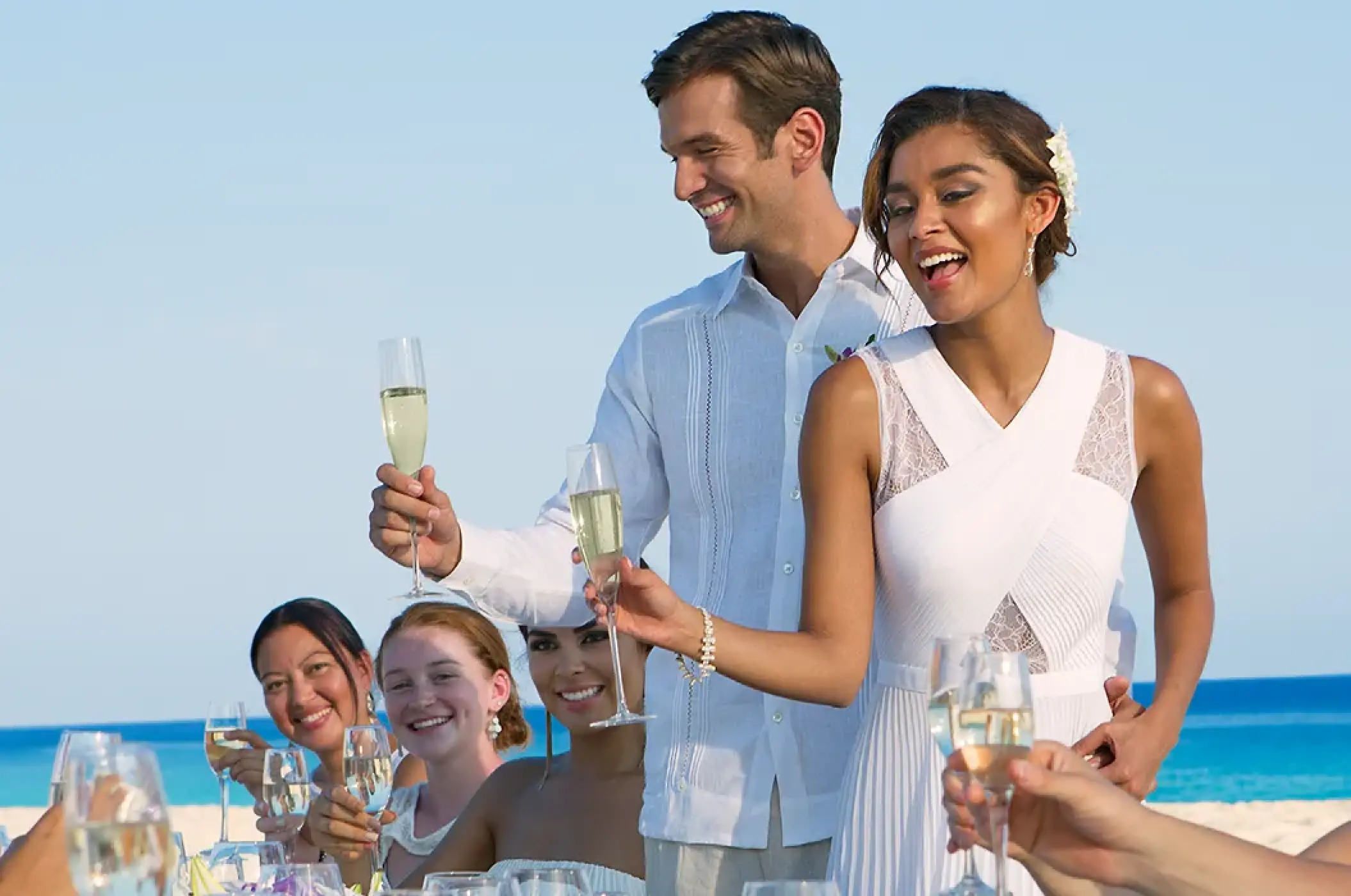 The couple and wedding guests raising a champagne toast at Dreams Cozumel Cape, Cozumel