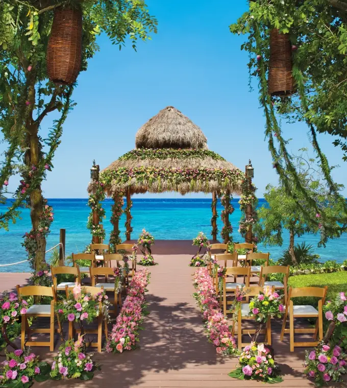 Thatched gazebo wedding ceremony with floral decor at Dreams Cozumel, Cozumel