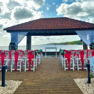 Waterfront gazebo wedding ceremony with red sashes at Dreams Curacao, Willemstad