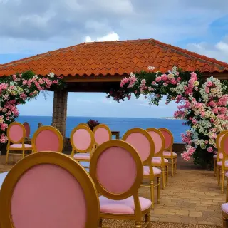 Oceanfront wedding ceremony gazebo with pink floral arrangements and chairs at Dreams Curacao, Willemstad