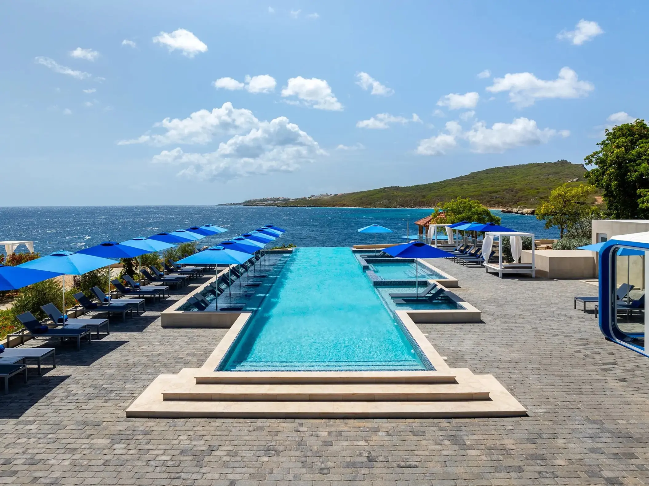 Il Mare infinity pool with blue umbrellas at Dreams Curacao, Willemstad