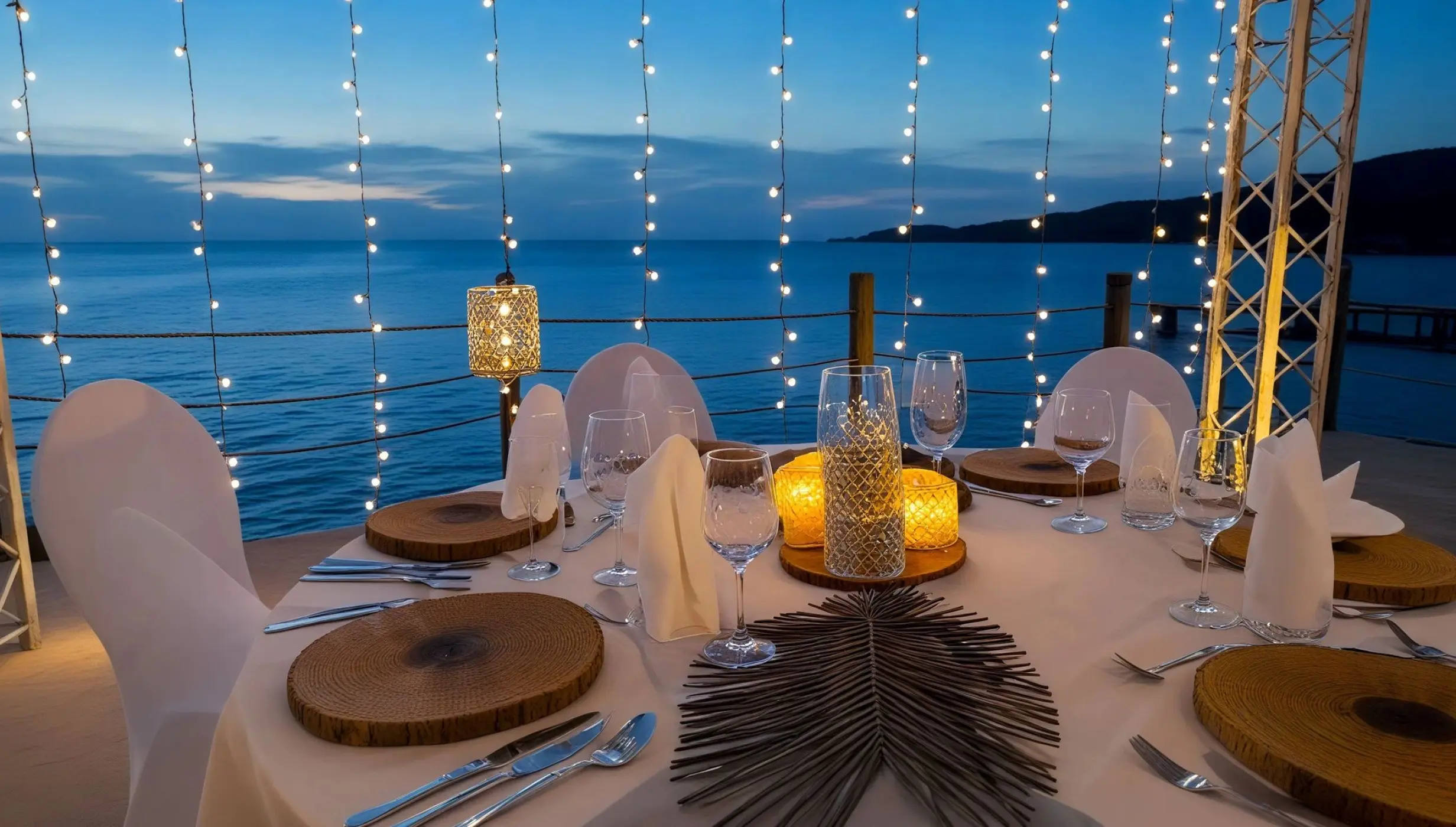 Oceanfront wedding reception table with string lights at Dreams Curacao, Willemstad