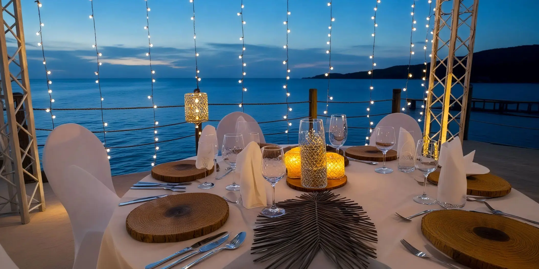Oceanfront wedding reception table with string lights at Dreams Curacao, Willemstad