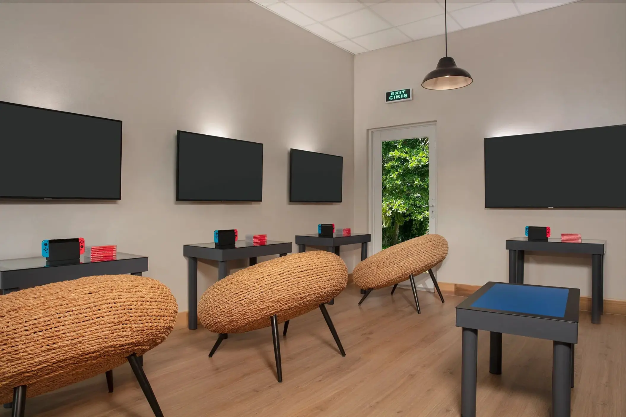 Video game room with wall-mounted screens and woven seating at Dreams Curacao, Willemstad