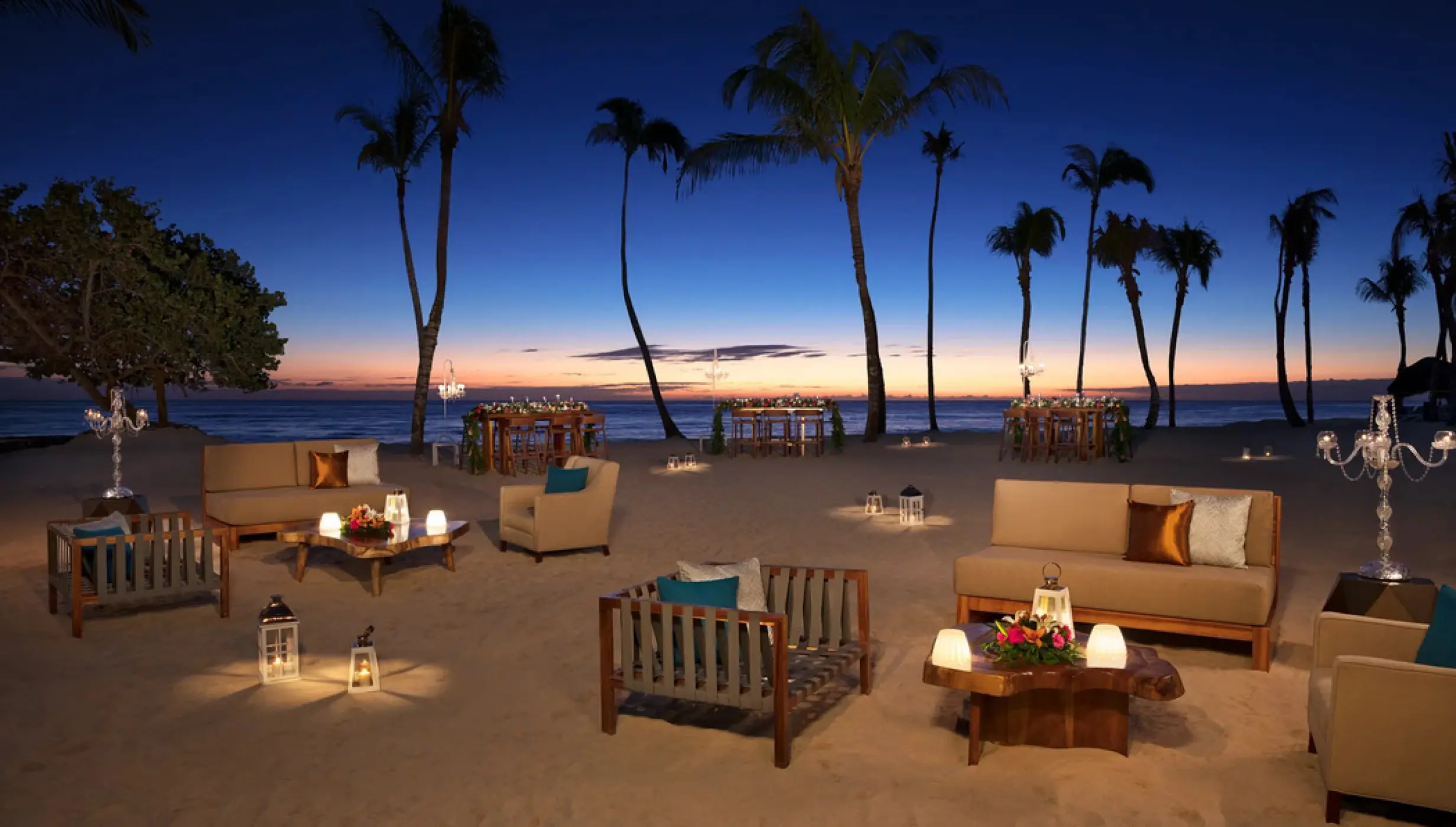 Beachfront wedding reception lounge with lanterns at dusk at Dreams Dominicus, La Romana