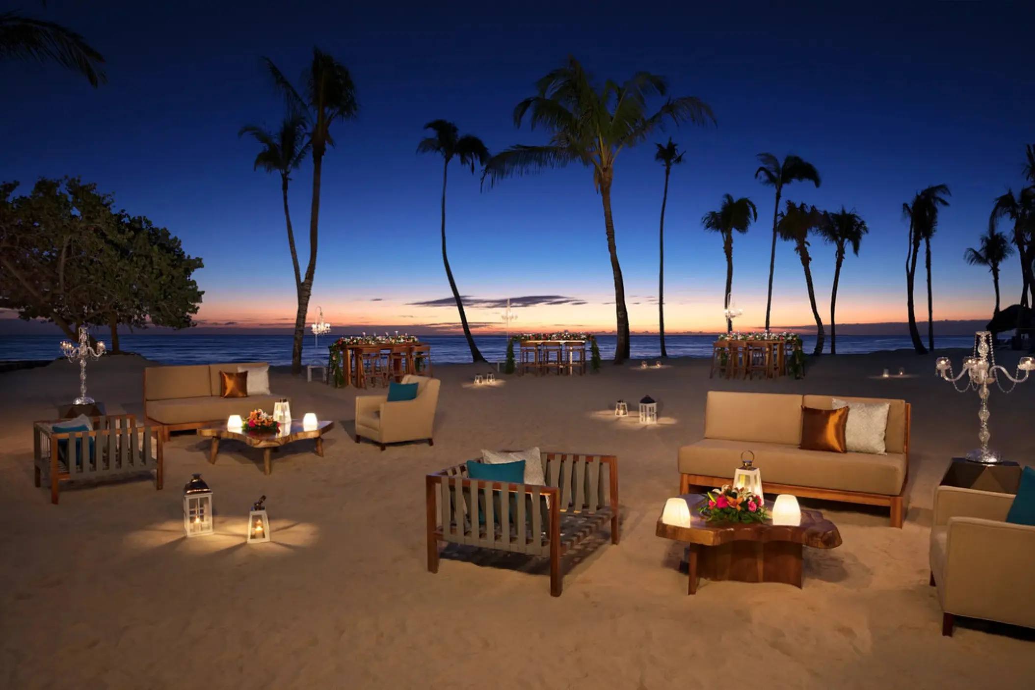 Beachfront wedding reception lounge with lanterns at dusk at Dreams Dominicus, La Romana