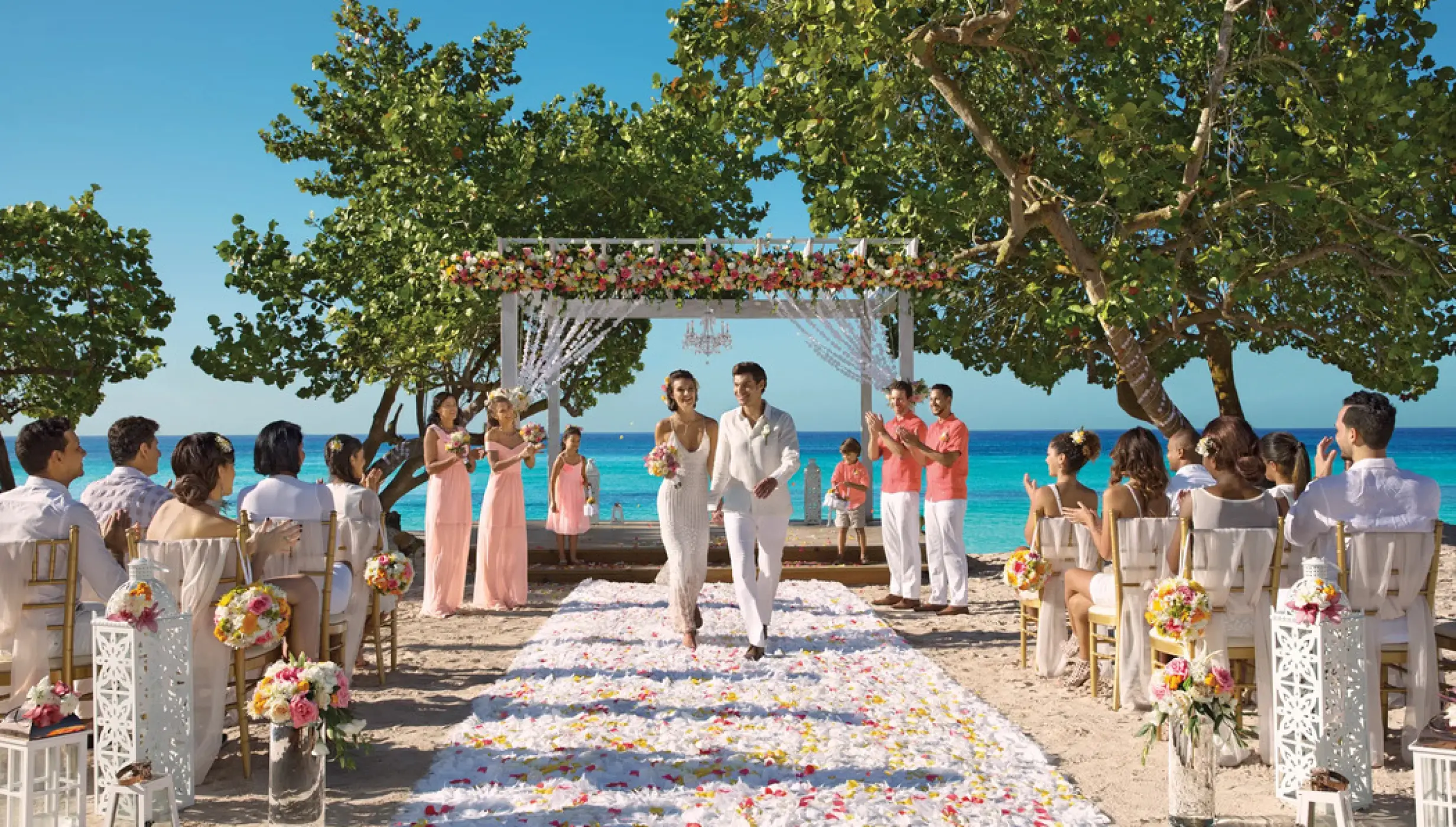 Bride and groom walking down a petal-covered aisle at Dreams Dominicus, La Romana beach ceremony
