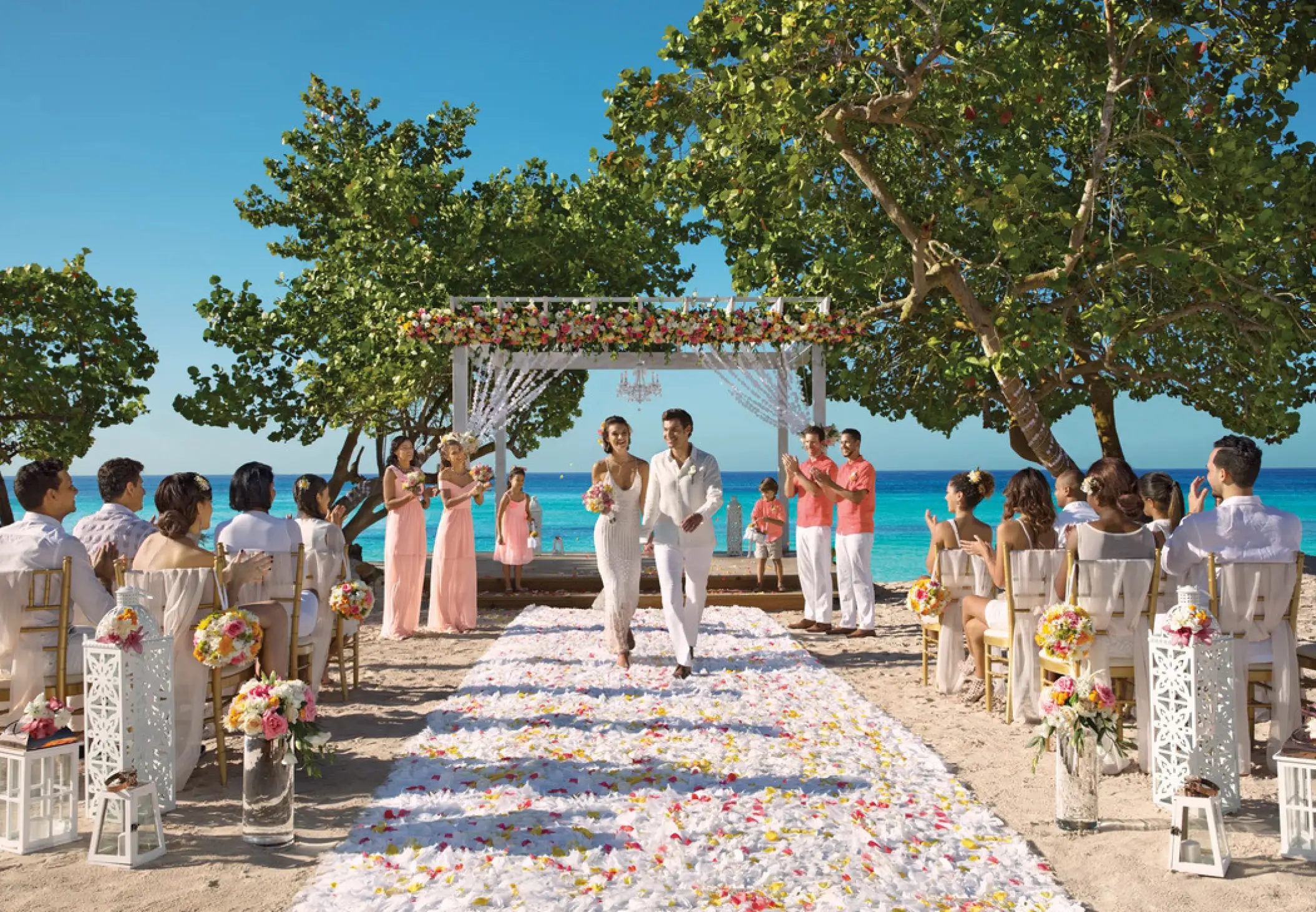 Bride and groom walking down a petal-covered aisle at Dreams Dominicus, La Romana beach ceremony