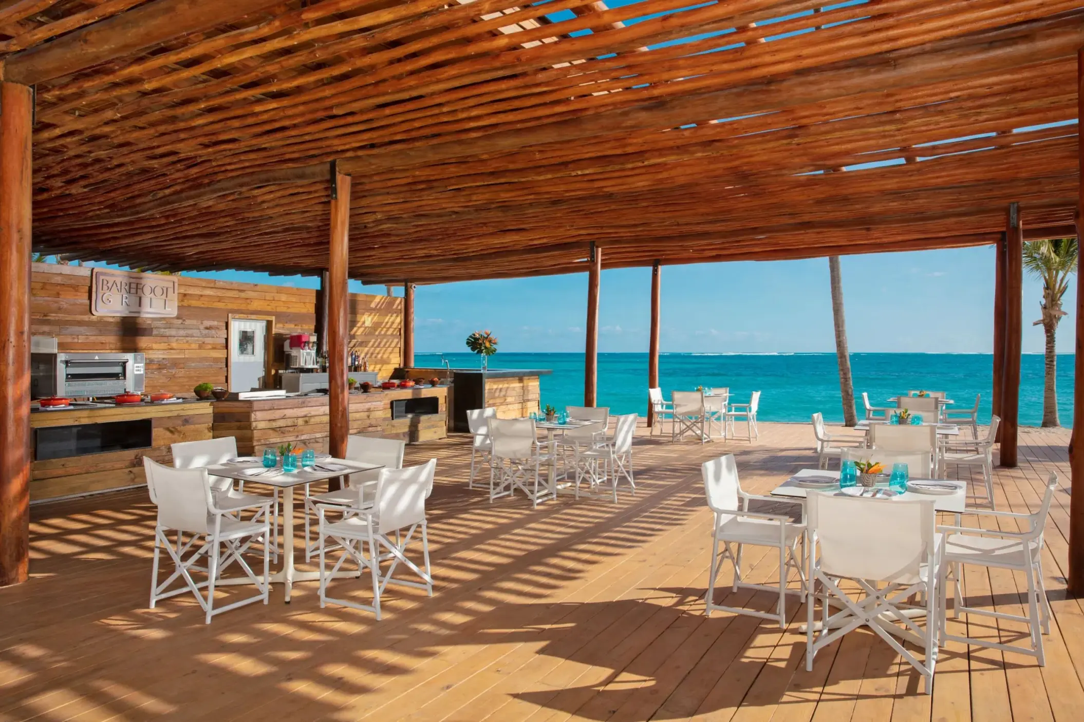 Barefoot Grill beachfront dining area under a wooden pergola at Dreams Flora, Punta Cana