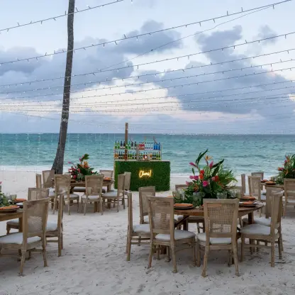 Beach wedding reception with string lights and floral centerpieces at Dreams Flora, Punta Cana