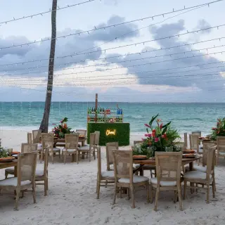 Beach wedding reception with string lights and floral centerpieces at Dreams Flora, Punta Cana