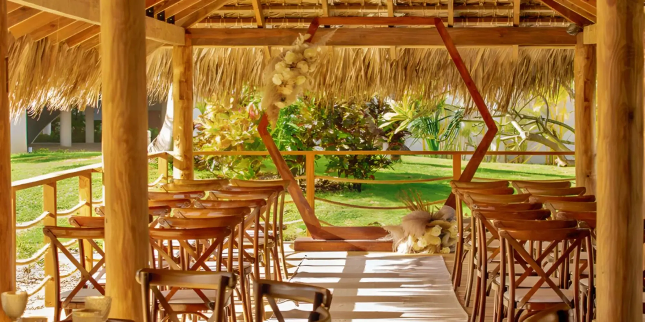 Palapa wedding ceremony with a wooden hexagonal arch at Dreams Flora, Punta Cana