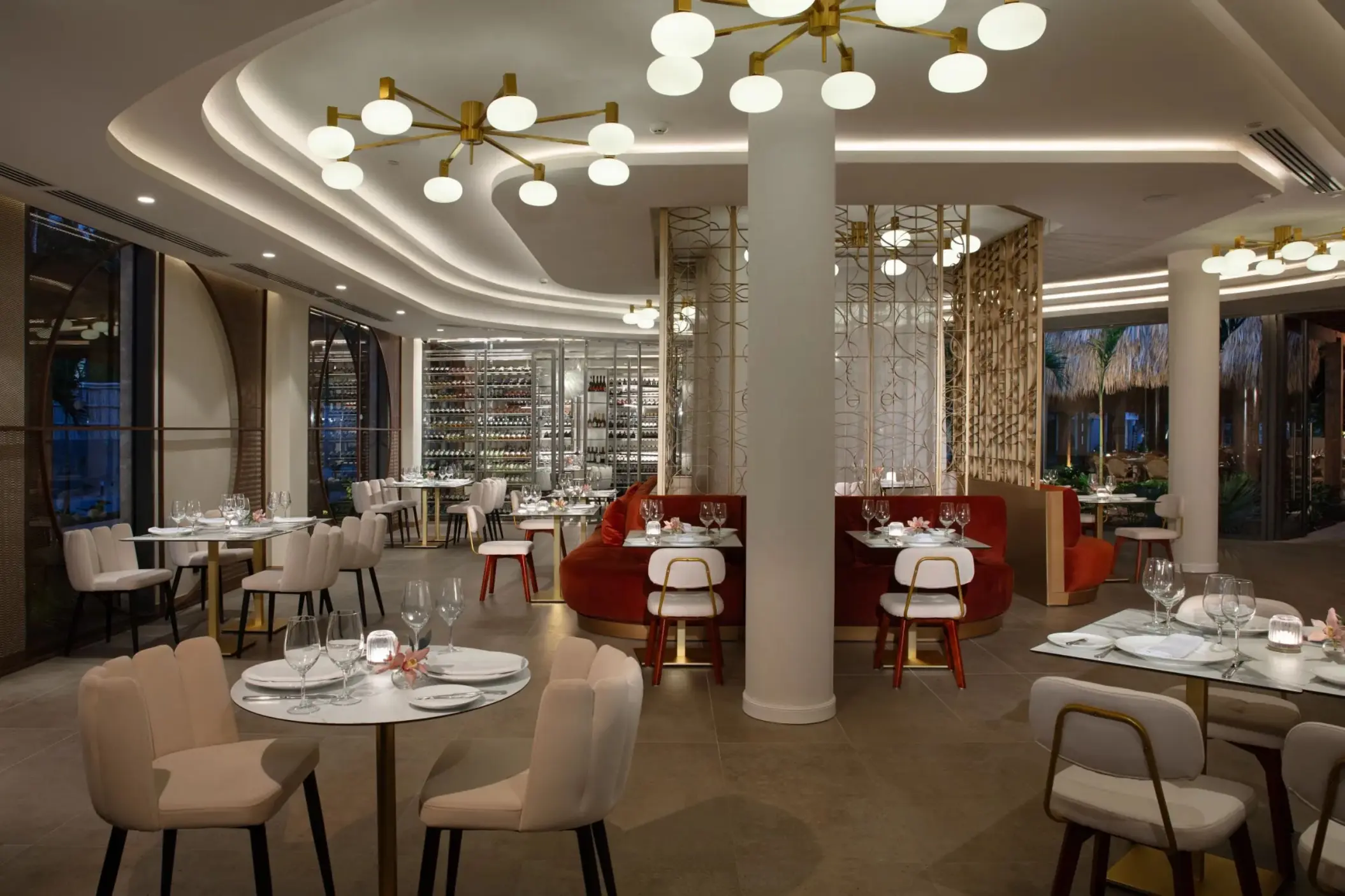Bordeaux restaurant dining area with modern light fixtures and red booths at Dreams Flora, Punta Cana