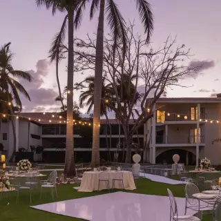 Outdoor garden wedding reception with string lights and white dance floor at Dreams Flora, Punta Cana