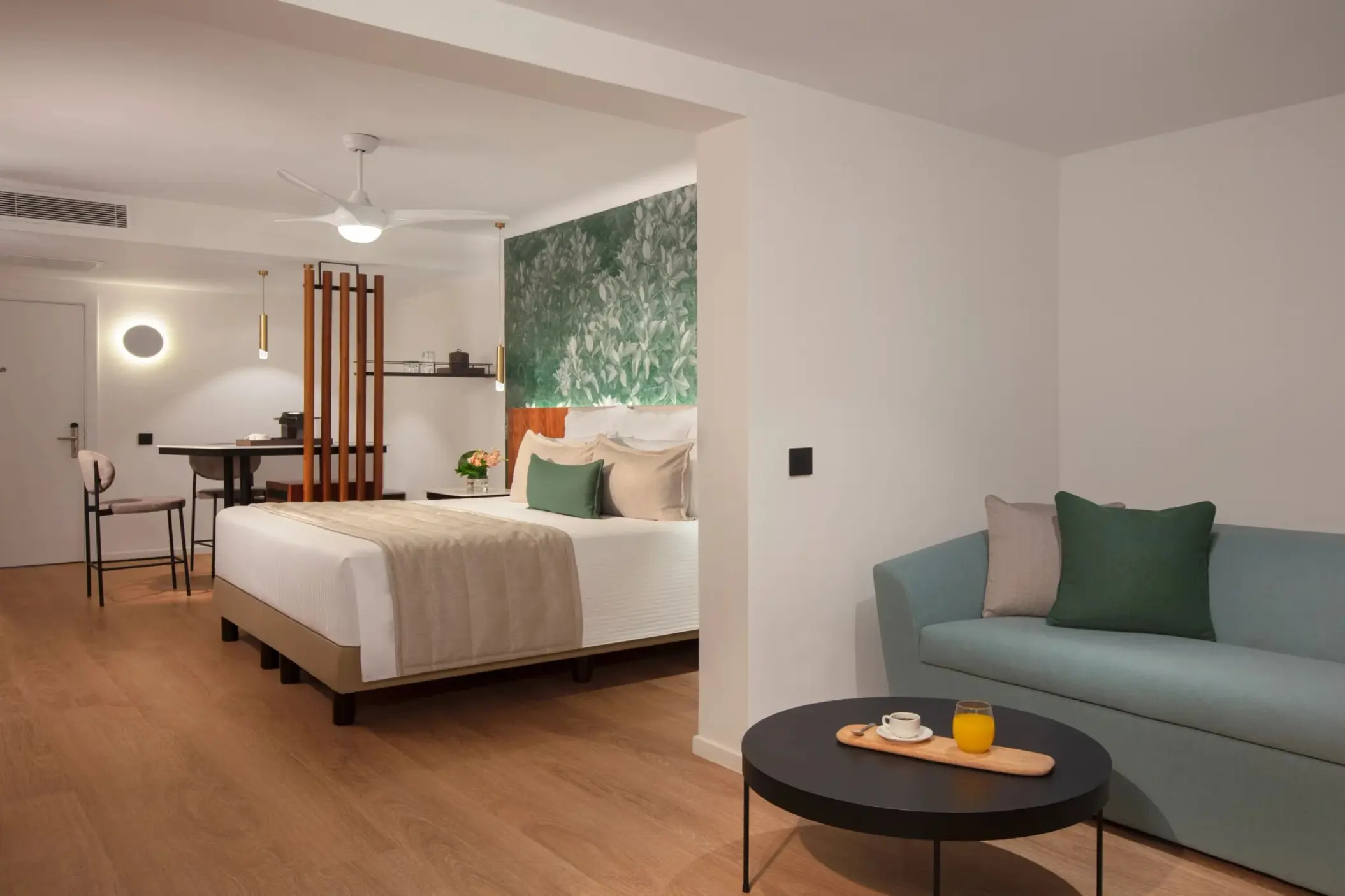 Junior suite with a blue sofa and modern bedroom at Dreams Flora, Punta Cana