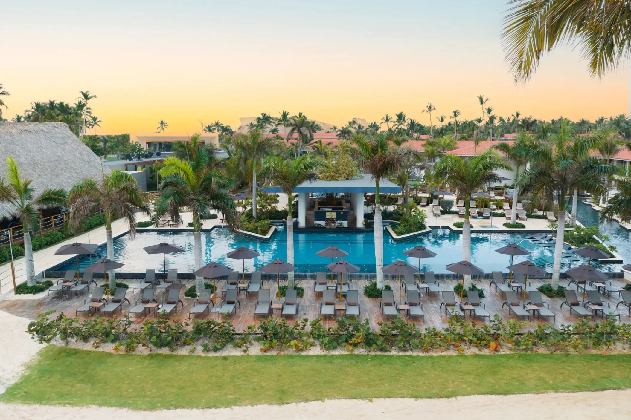 Preferred Club family pool with lounge chairs and palm trees at Dreams Flora, Punta Cana