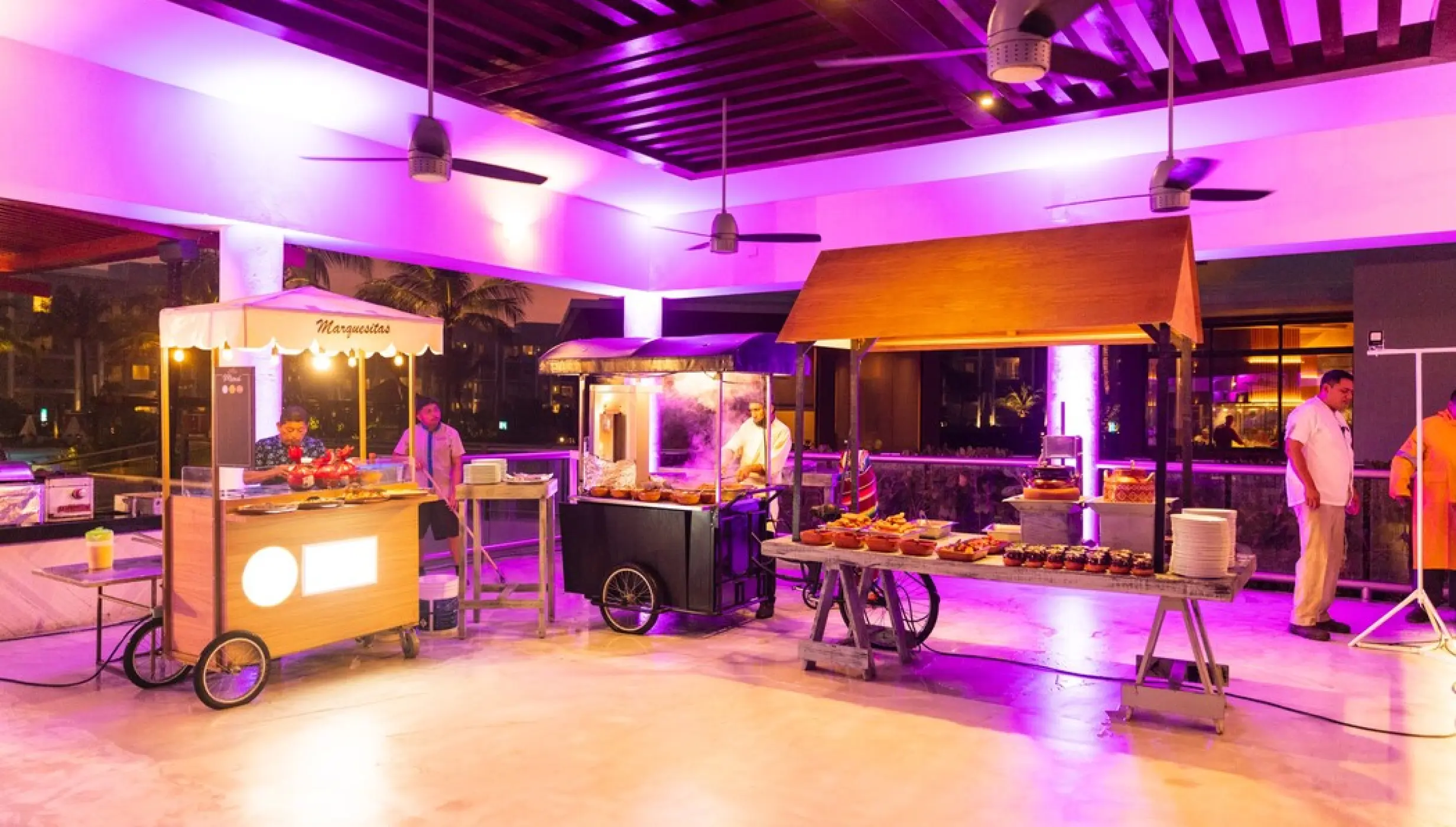 Indoor wedding reception food carts with purple lighting at Castaways restaurant in Dreams Jade, Riviera Maya