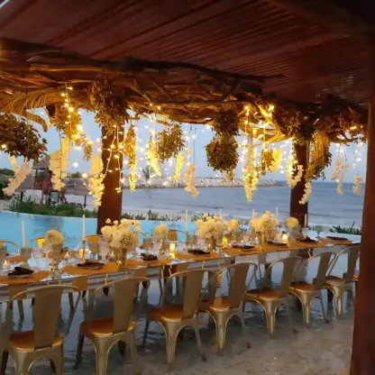 Water pergola wedding reception setup with gold chairs and fairy lights at Dreams Jade, Riviera Maya
