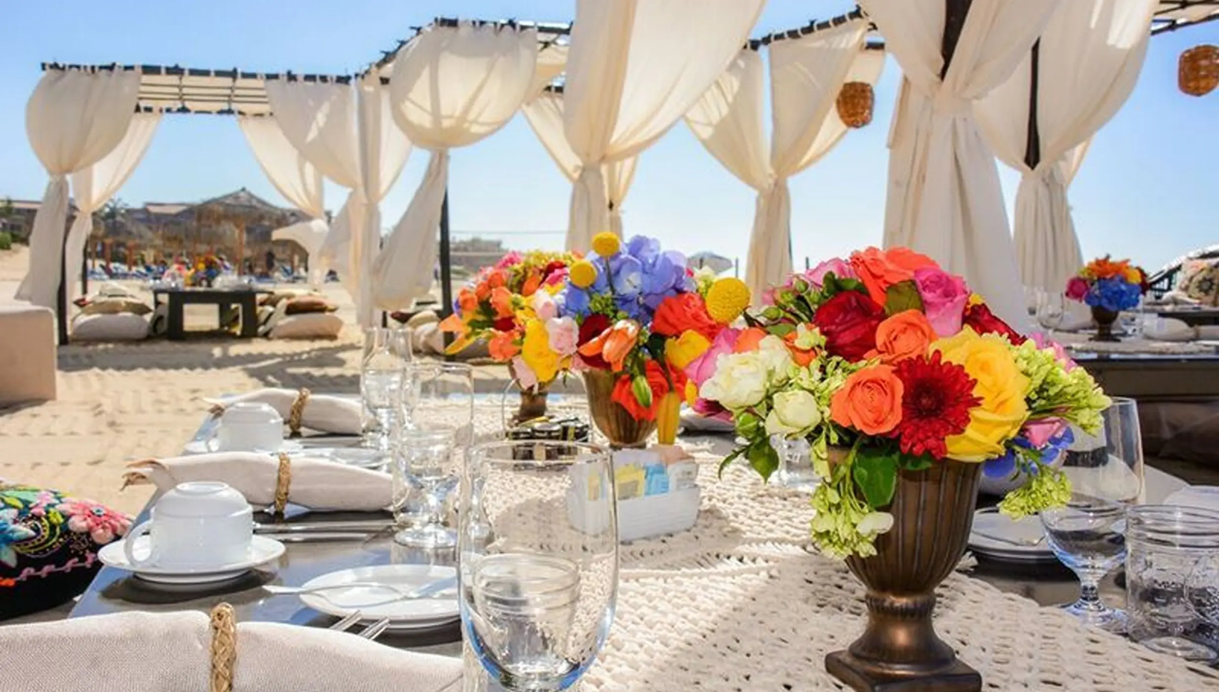 Colorful floral centerpieces on a reception table at Dreams Los Cabos, Cabo San Lucas