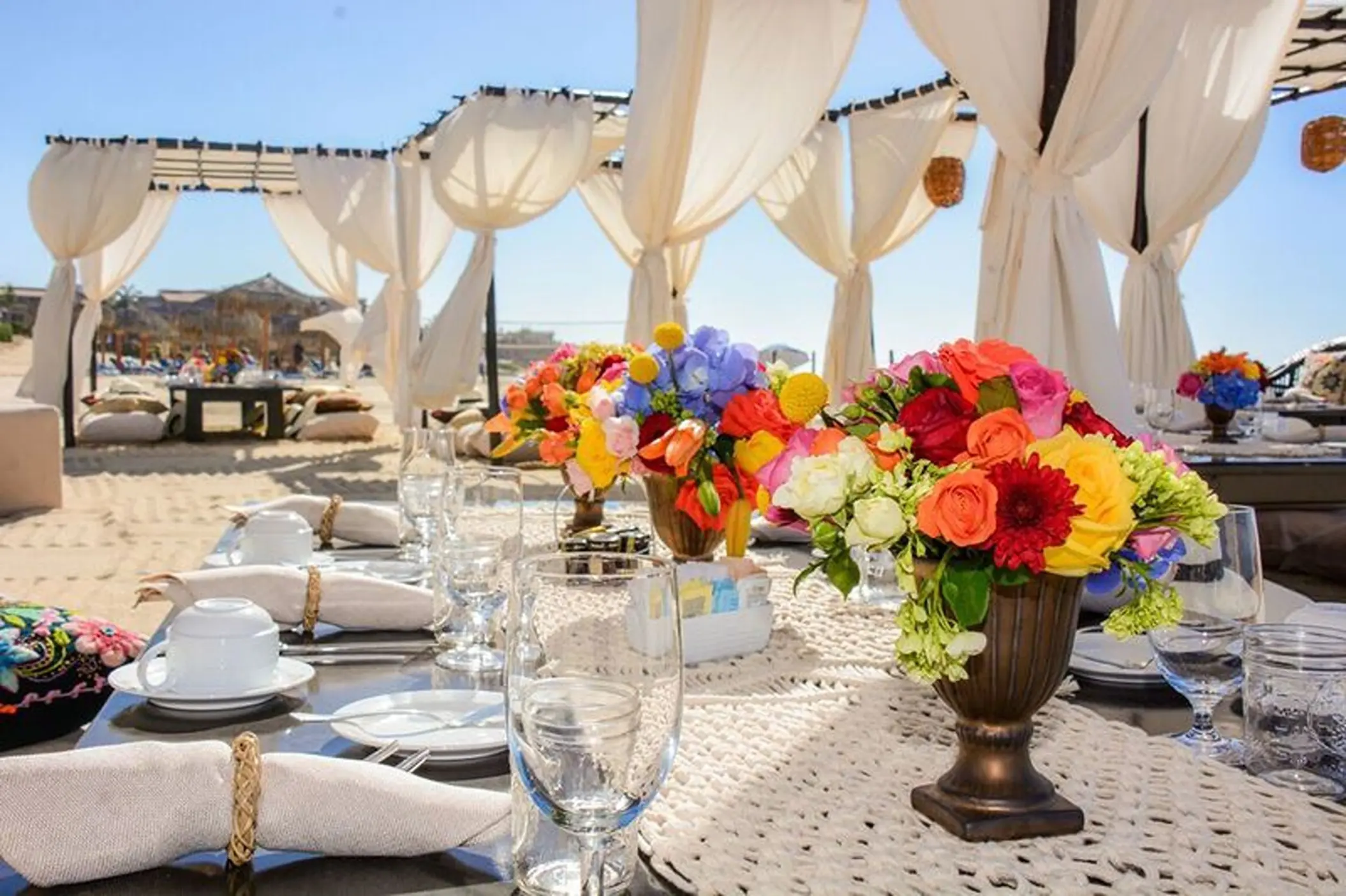 Colorful floral centerpieces on a reception table at Dreams Los Cabos, Cabo San Lucas