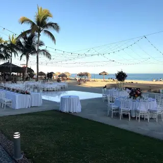 Outdoor wedding reception with white tables and dance floor at Dreams Los Cabos, Cabo San Lucas