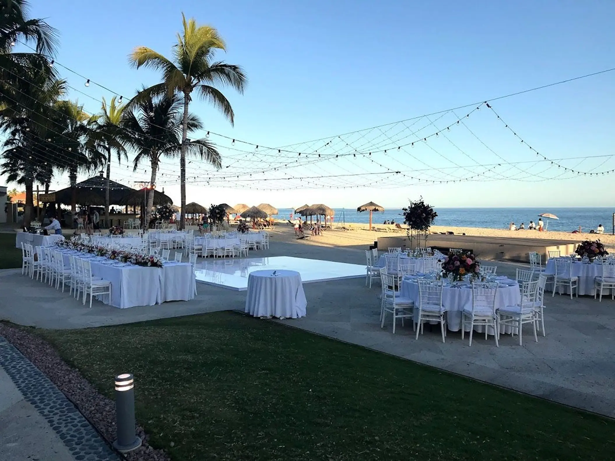 Outdoor wedding reception with white tables and dance floor at Dreams Los Cabos, Cabo San Lucas