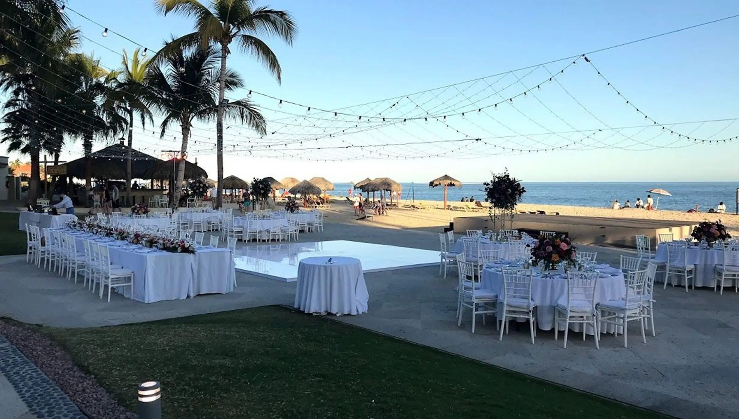 Outdoor wedding reception with white tables and dance floor at Dreams Los Cabos, Cabo San Lucas