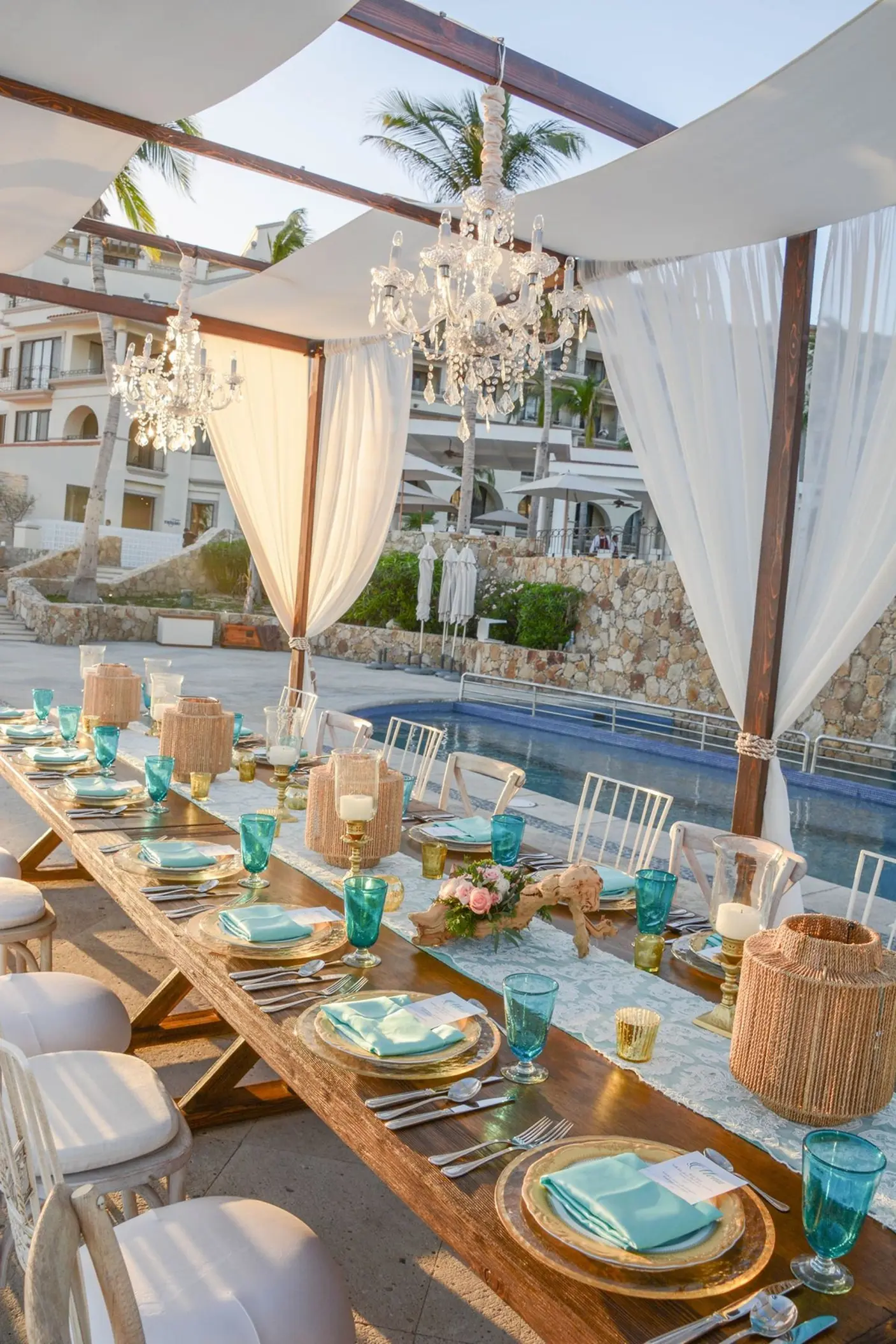 Cascade Terrace wedding reception with chandeliers and turquoise accents at Dreams Los Cabos, Cabo San Lucas