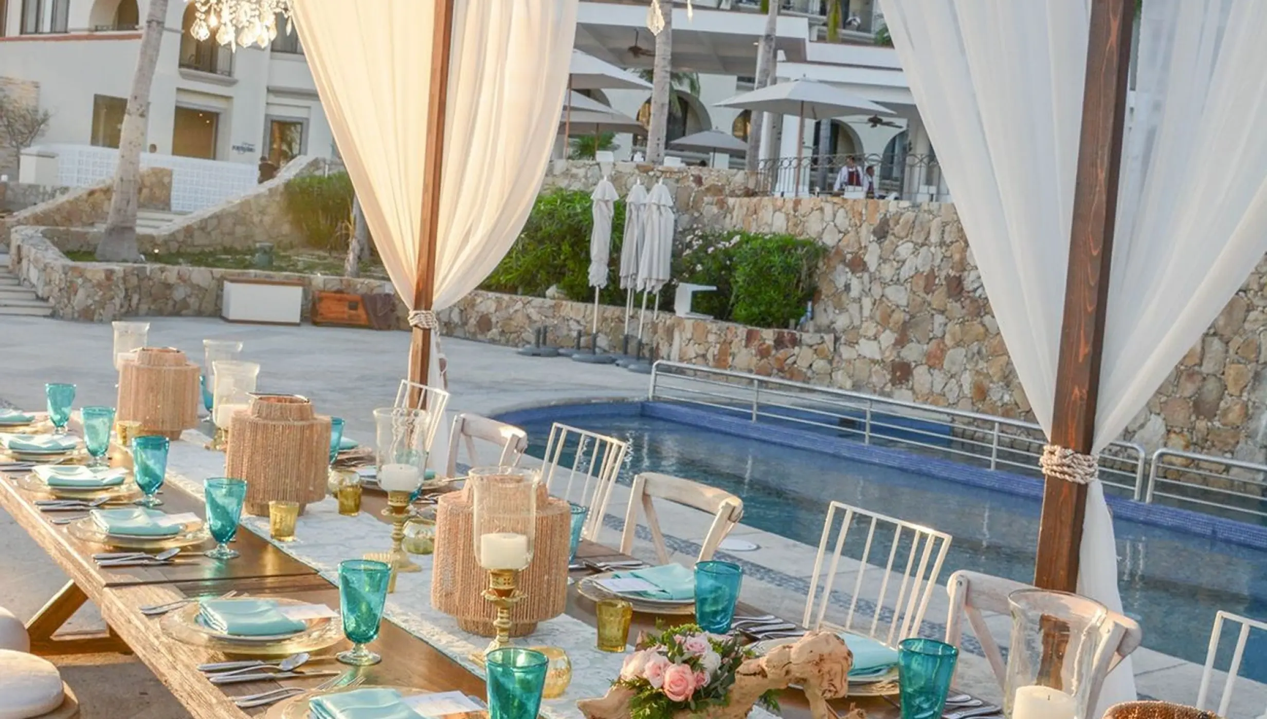 Cascade Terrace wedding reception with chandeliers and turquoise accents at Dreams Los Cabos, Cabo San Lucas