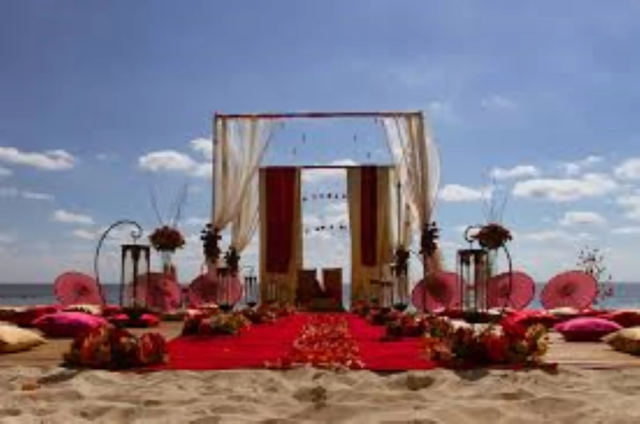 South Asian wedding mandap with red aisle runner on the beach at Dreams Los Cabos, Cabo San Lucas