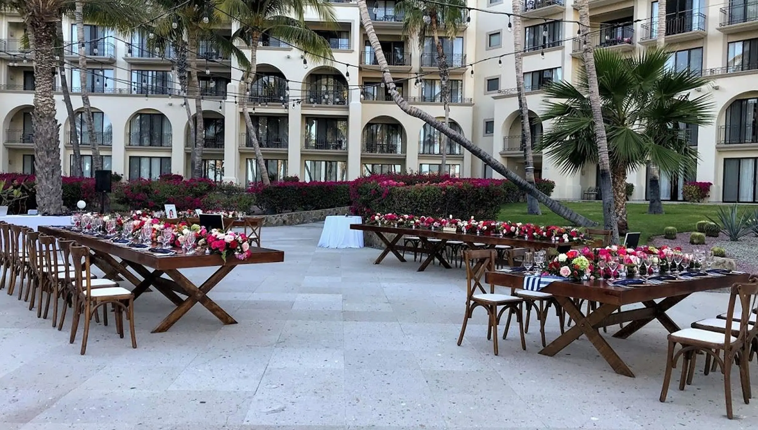Oceana Terrace wedding reception setup with long wooden tables and floral arrangements at Dreams Los Cabos