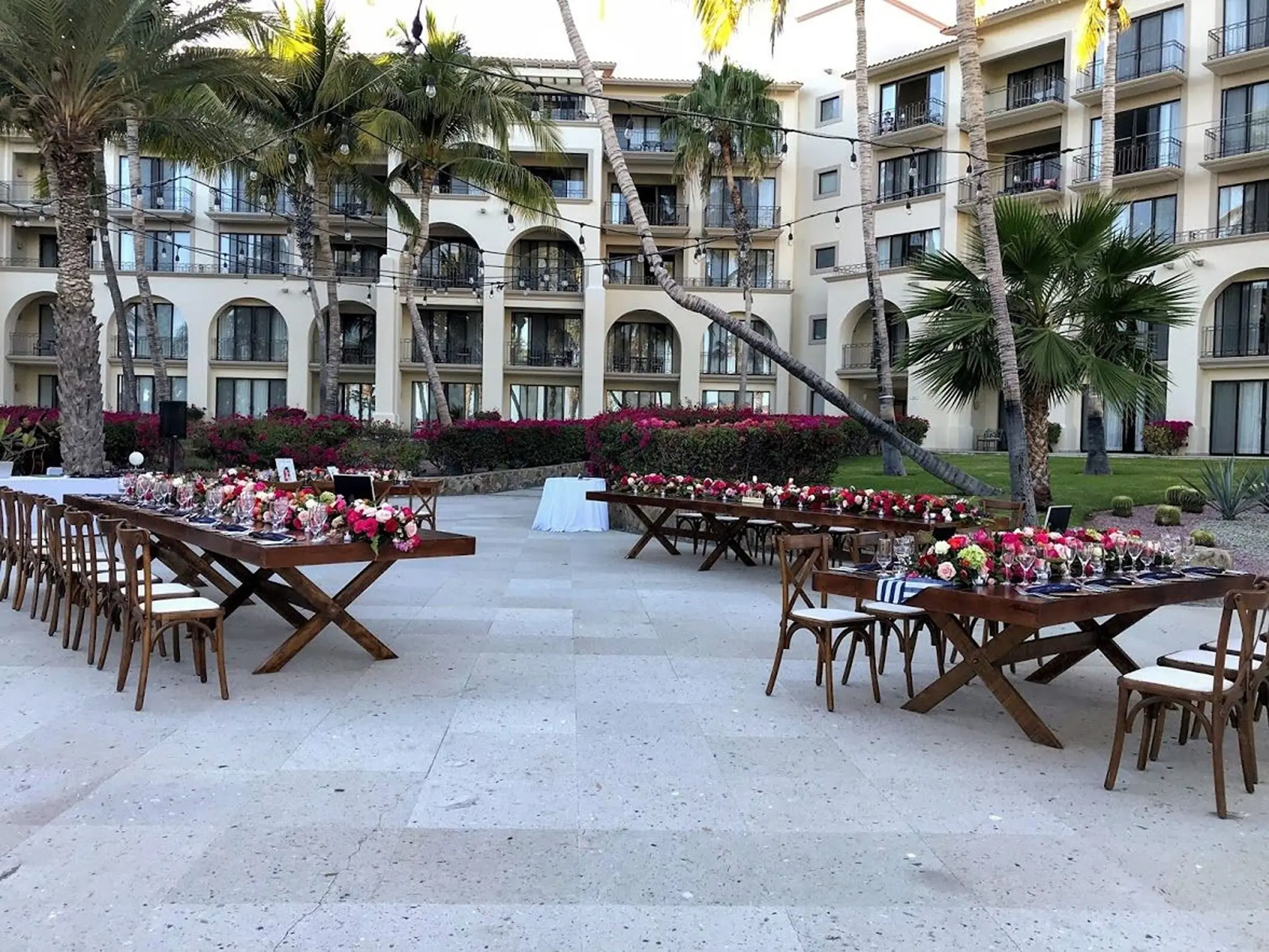 Oceana Terrace wedding reception setup with long wooden tables and floral arrangements at Dreams Los Cabos