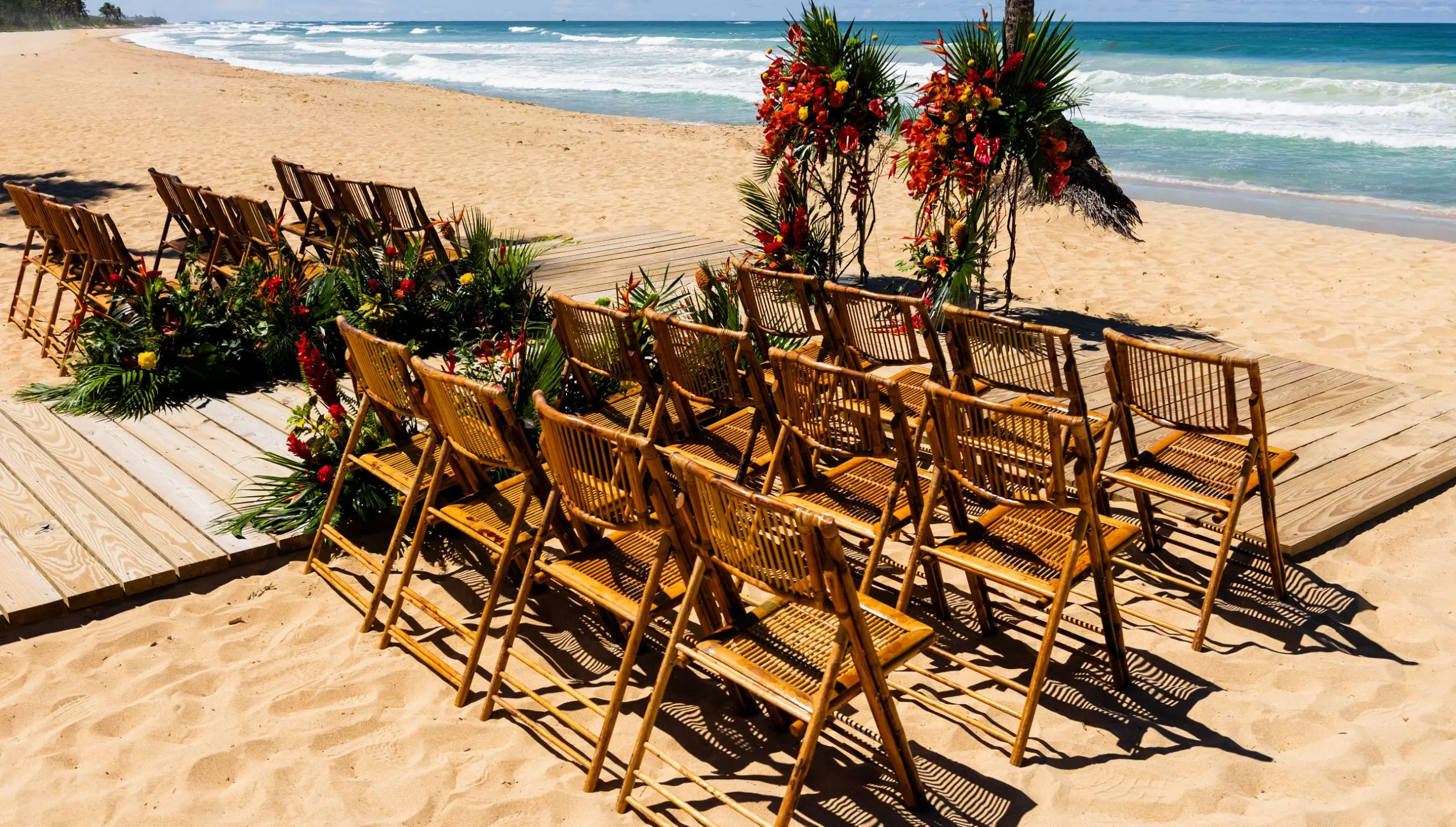 Beachfront wedding ceremony with wooden chairs and tropical floral arrangements at Dreams Macao Beach, Punta Cana
