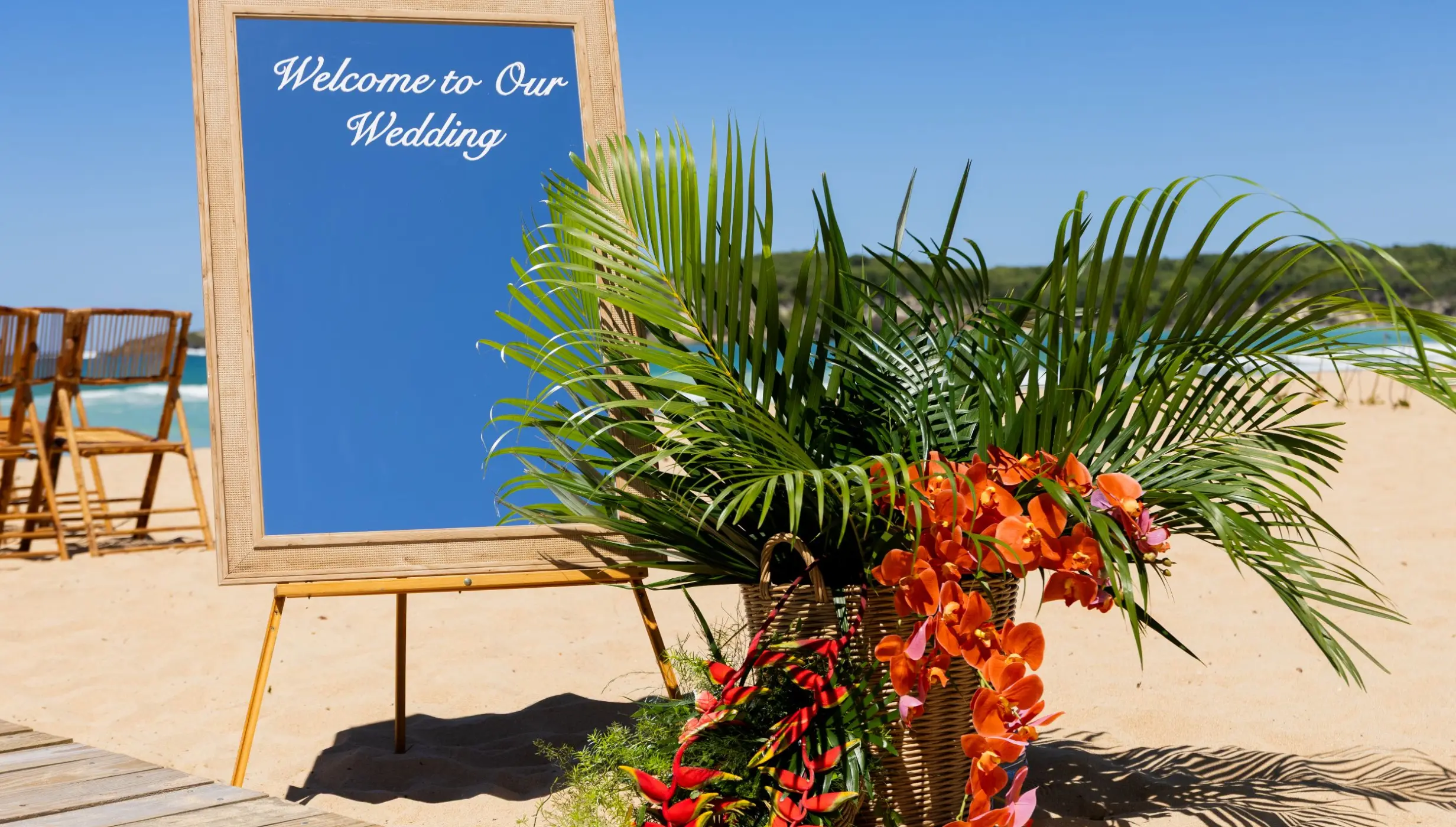 Welcome sign with tropical floral arrangement for a beach ceremony at Dreams Macao Beach, Punta Cana