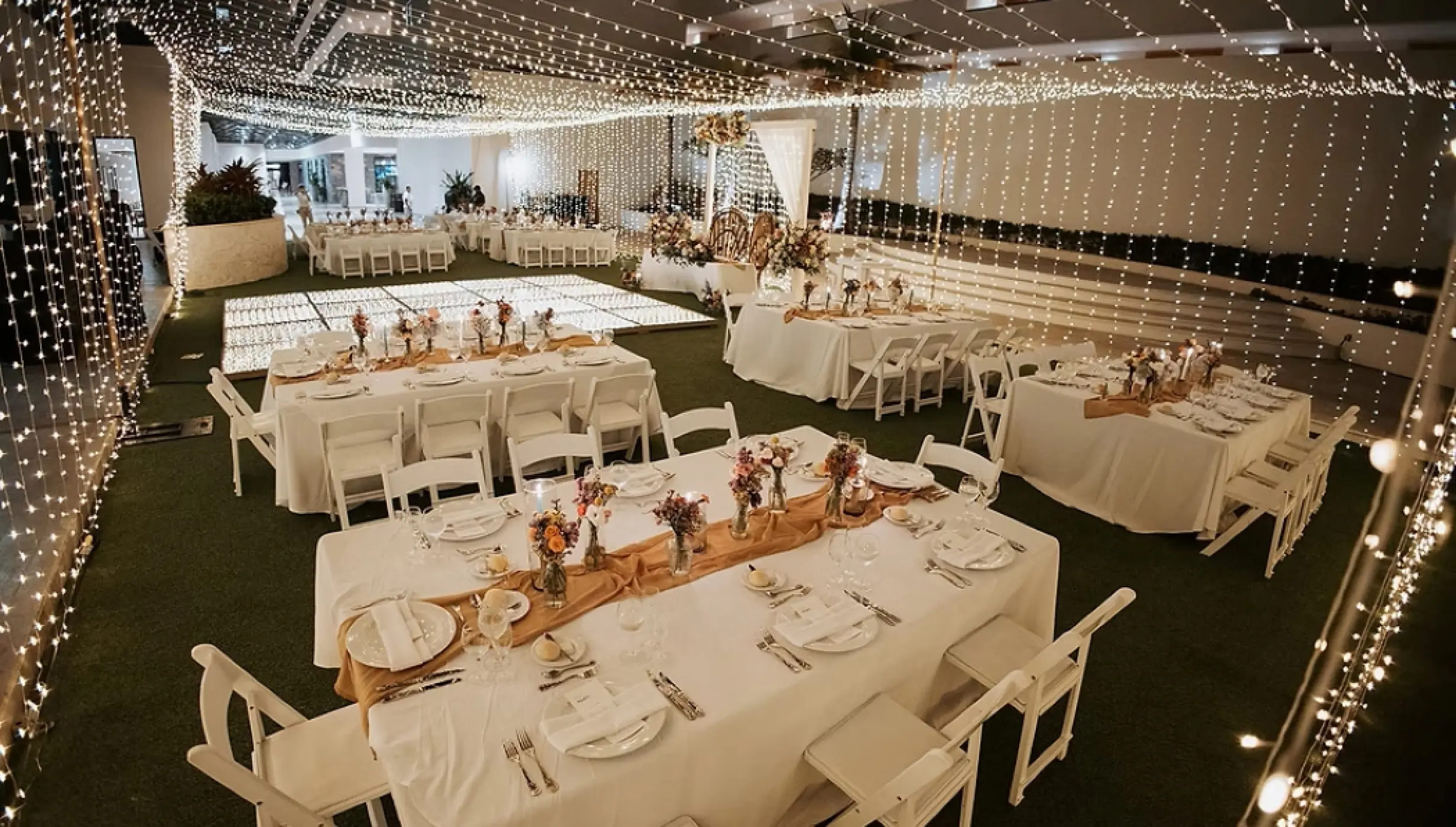 Indoor garden wedding reception at Dreams Natura, Riviera Maya featuring string lights and white table settings