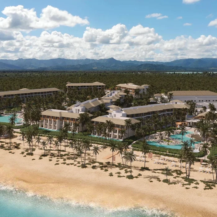 A stunning aerial view of the Dreams Playa Esmeralda resort, showcasing the pools, palm trees, and beach.