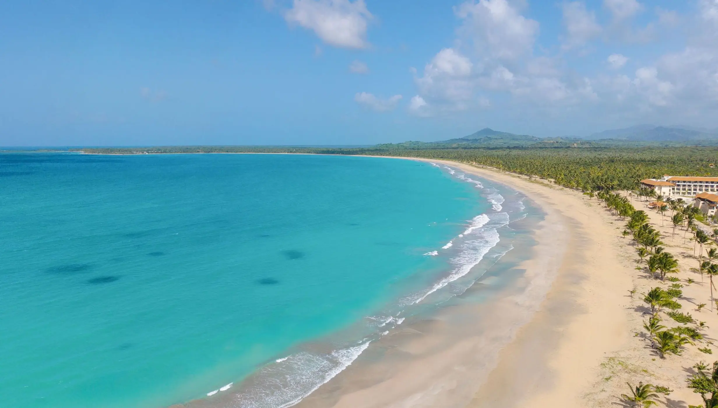 Aerial view of turquoise water and the white sand beach at Dreams Playa Esmeralda, Miches