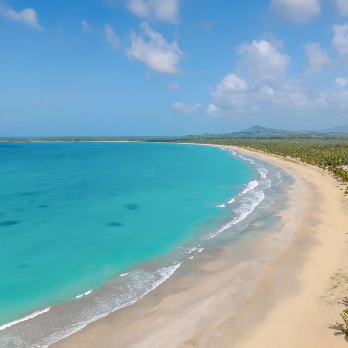 An aerial view of the long, pristine sandy beach and turquoise water at Dreams Playa Esmeralda resort.