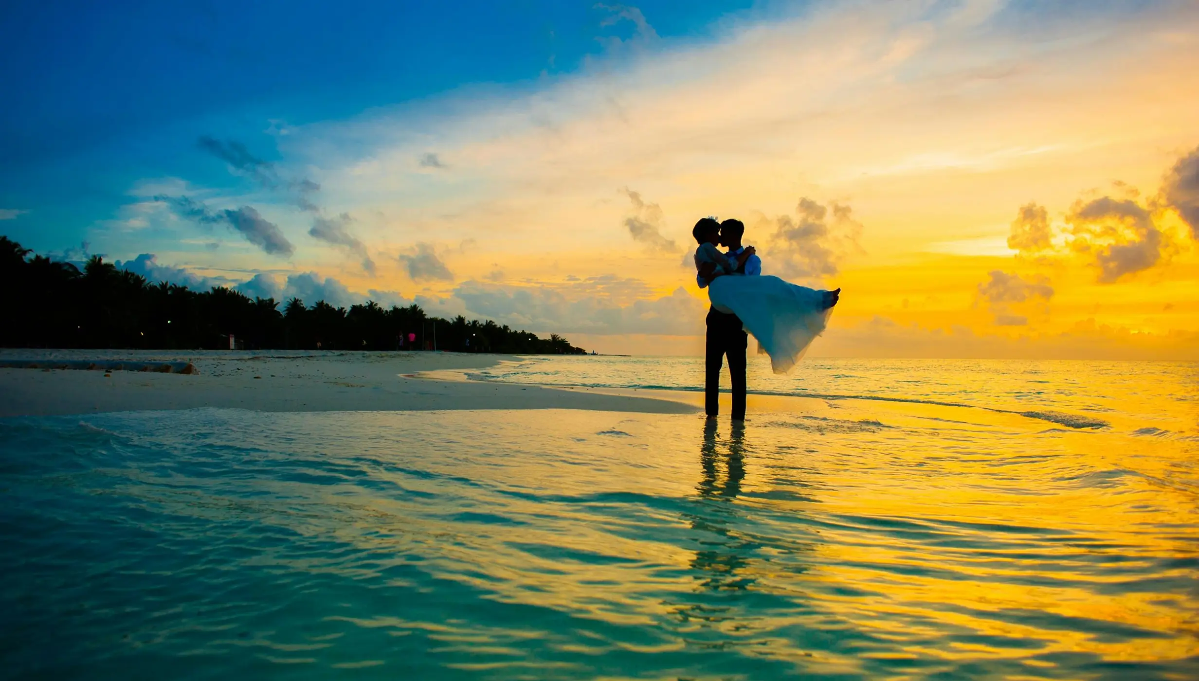 Groom carrying bride on the beach during sunset at Dreams Playa Esmeralda, Miches