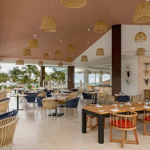 Open-air restaurant with woven light fixtures at Dreams Puerto Morelos, Riviera Maya