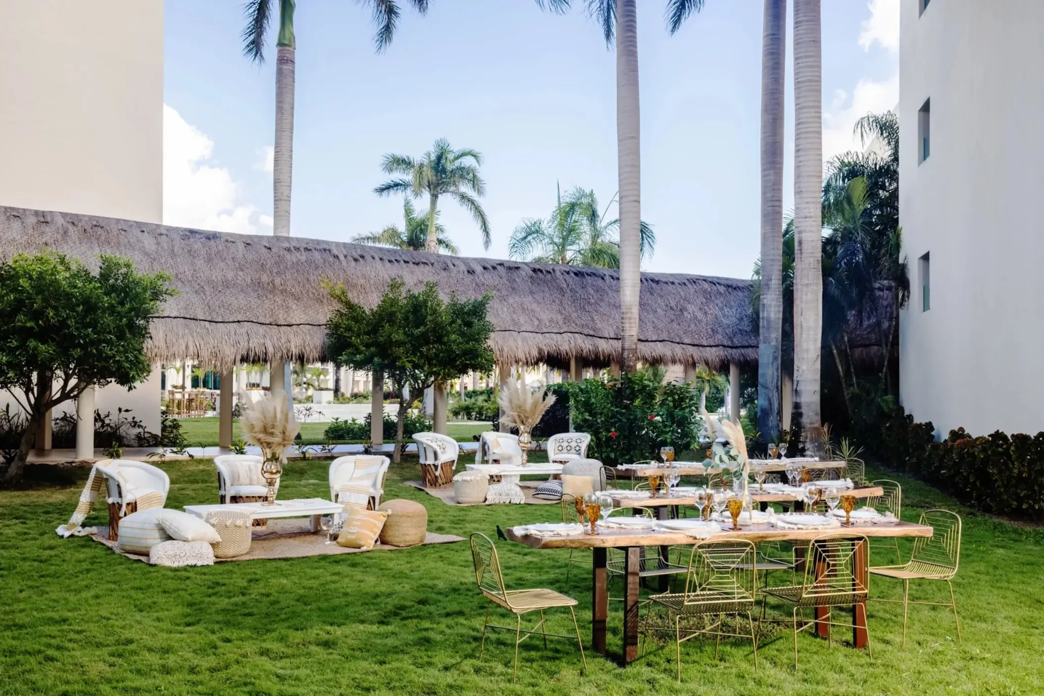 Avocado Garden wedding reception with wooden tables and lounge seating at Dreams Puerto Morelos, Riviera Maya