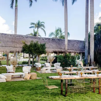 Avocado Garden wedding reception with wooden tables and lounge seating at Dreams Puerto Morelos, Riviera Maya
