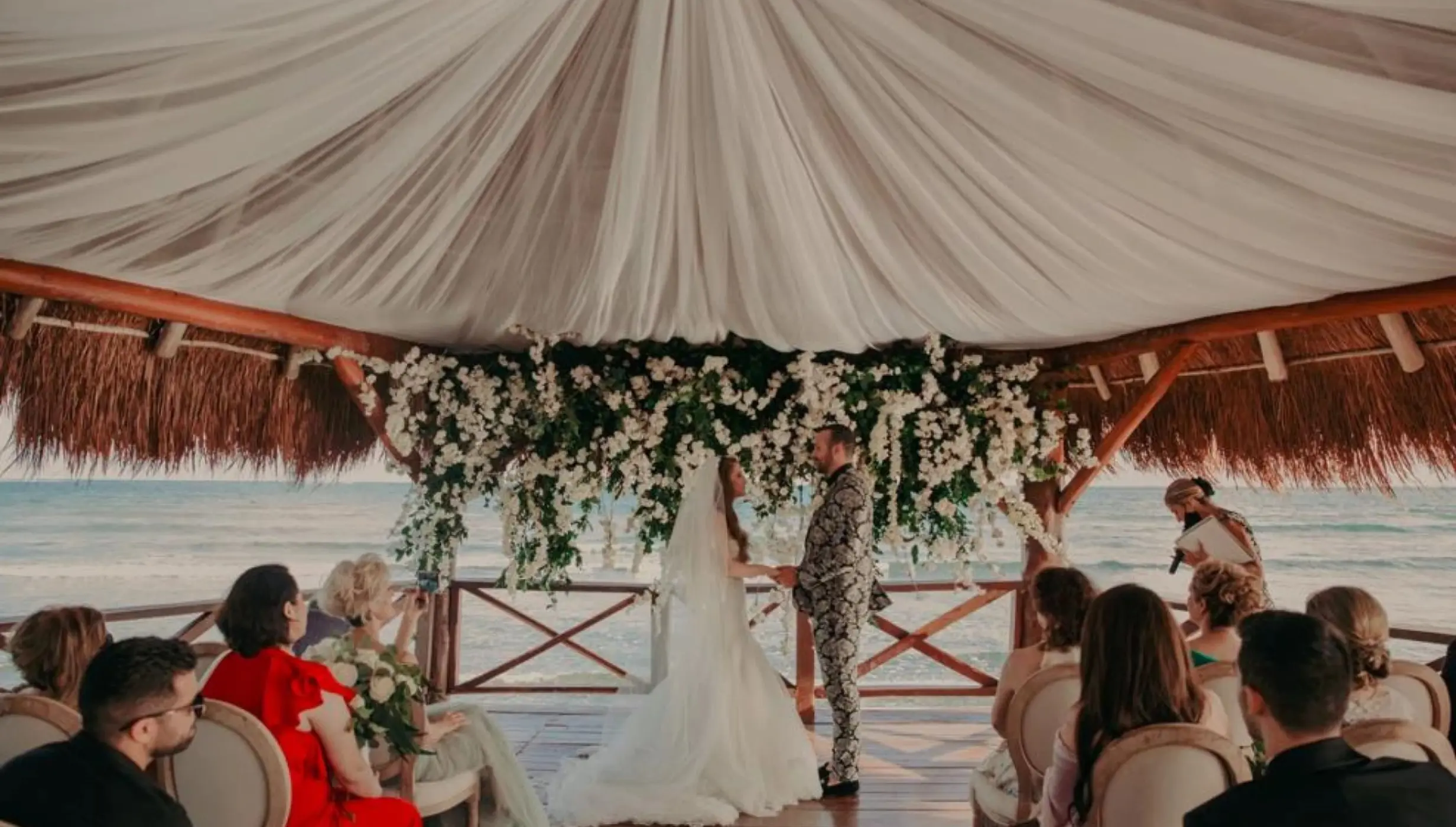 bride, groom, and guests at the overwater gazebo at Dreams Puerto Morelos Resort & Spa