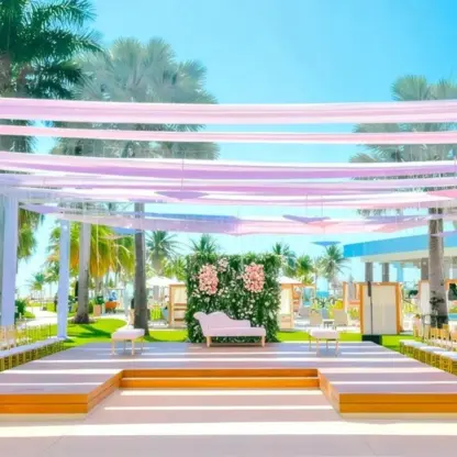 Guava Garden wedding ceremony setup with pink fabric draping and gold chairs at Dreams Puerto Morelos, Riviera Maya