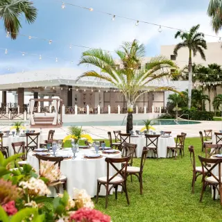 Guava Garden wedding reception with round tables and cross-back chairs at Dreams Puerto Morelos, Riviera Maya